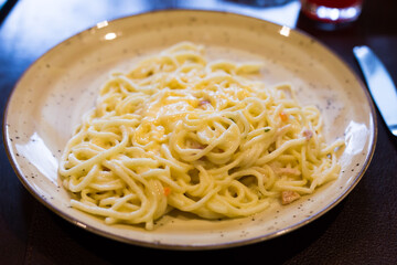 Portion of spaghetti carbonara on a plate in a restaurant