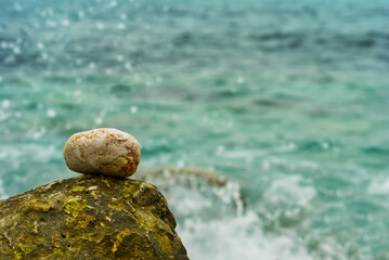 Fototapeta na wymiar closeup heap of stones on emerald sea coast