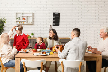 Happy family playing word guessing game at festive table on Thanksgiving Day