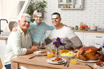 Happy family playing word guessing game at festive table on Thanksgiving Day
