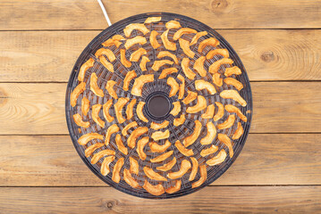 Top view of an open dryer for vegetables and fruits with dried apples.