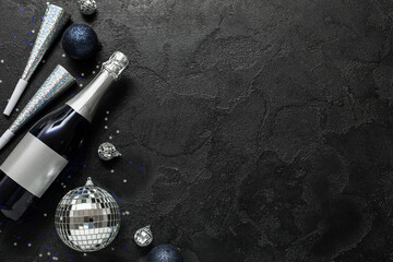 Beautiful composition with bottle of champagne and decorations for New Year party on black...
