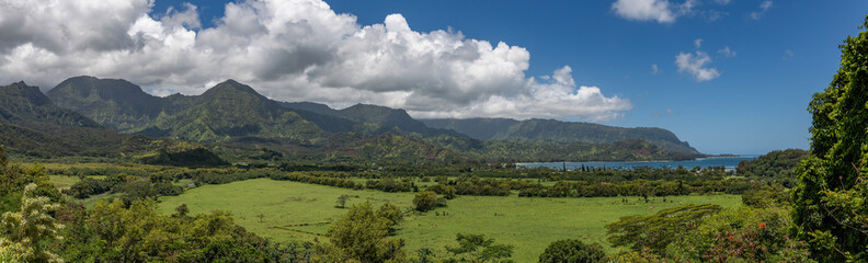 Fototapeta na wymiar A panoramic view from the Hanalei Bay Lookout of the lush valley, mountains and the Pacific Ocean in Kauai, Hawaii, United States. 