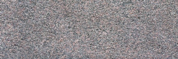 Granite texture. Natural granite with a grainy pattern. Stone background. Solid rough surface of rock. Durable construction and decoration material. Close-up.