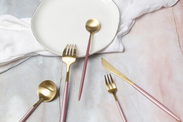 Creative shot of golden cutlery on marble table, Design concept. Modern kitchen. Scandinavian style tableware.	