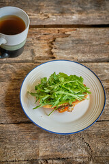 hot sandwich with arugula. wooden background.