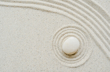 Fototapeta na wymiar White zen stone on sand sound ripples meditation garden