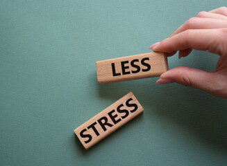 Less stress symbol. Wooden blocks with words Less stress. Doctor hand. Beautiful grey green...
