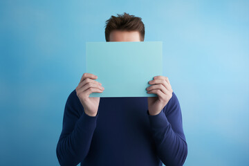 person covers his face with cardboard, space for message