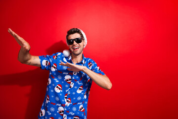 Photo of pleasant man wear sunglass santa hat print shirt dancing celebrate christmas holidays isolated on red bright color background