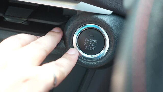 Finger pressing button to off car engine, initiating car turns off process. Automotive technology and convenience. Turning off engine systems vehicle auto. Press luxury modern electronic auto key
