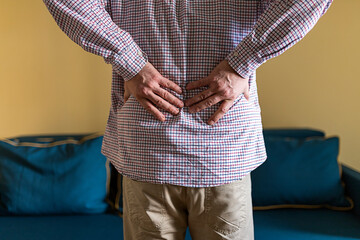 Man Is Touching His Back Because It Aches. Backache Concept Bending Over In Pain With Hands Holding...