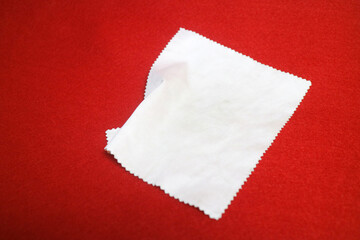 brightly colored cloth that serves to wipe glasses, on a red background
