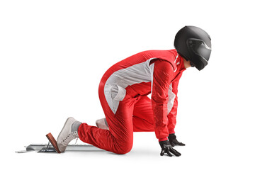 Full length profile shot of a racer with a helmet kneeling on starting blocks preparing for a run