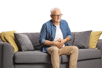 Mature man with abdominal pain sitting on a sofa isolated on white background