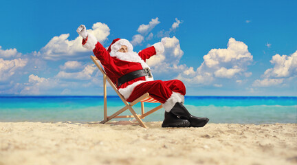Excited Santa claus on a deck chair sitting at the beach