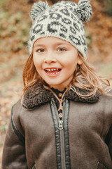 beautiful little girl wearing a winter outfit, a hat and a jacket