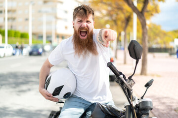 Redhead man with beard with a motorcycle