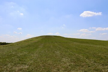 The green grass hill in the countryside on a sunny day.