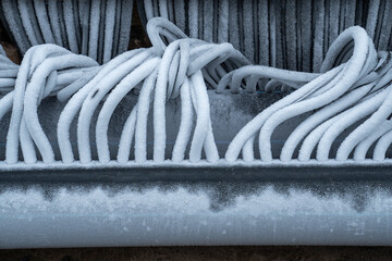 Twisted flexible refrigerated hoses covered with hoarfrost. Engineering system for skating rink...
