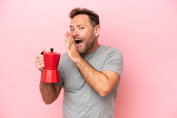 Middle age caucasian man holding coffee pot isolated on pink background whispering something