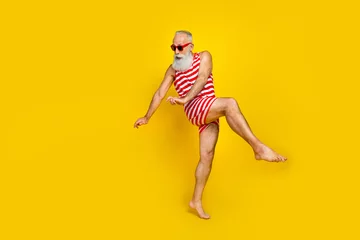 Fotobehang Full length photo of impressed funny senior man wear red striped swimsuit dancing discotheque empty space isolated yellow color background © deagreez