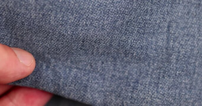 blue denim fabric made of cotton, details of a piece of clothing sewn from blue denim