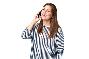 Middle age woman over isolated background keeping a conversation with the mobile phone