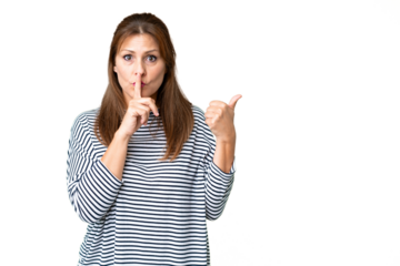 Middle age woman over isolated background pointing to the side and doing silence gesture