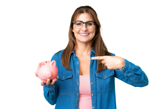 Middle age caucasian woman holding a piggybank over isolated background and pointing it