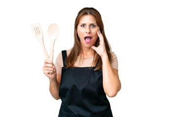 Middle age caucasian woman holding a rolling pin over isolated background with surprise and shocked...