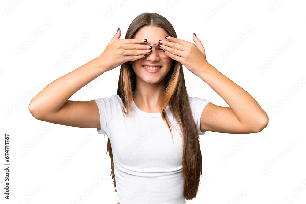 Wall mural Teenager caucasian girl over isolated background covering eyes by hands and smiling