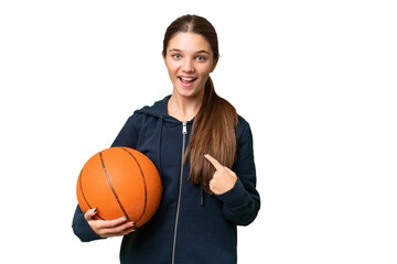 Teenager caucasian girl playing basketball over isolated background with surprise facial expression