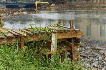 A river fishing pier with reeds in the summer afternoon in Jakarta