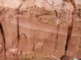 Obraz premium Erosion of an ancient red-yellow lateritic soil. Geological structure of a clayey soil in equatorial Africa.