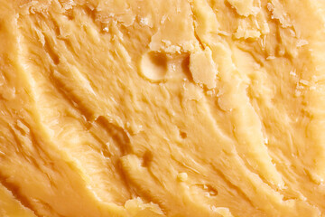 Close-up image, texture of yellow colored, hard cheese, Cheddar. Traditional taste of Italian cheese. Salty and delicious. Concept of food, taste, art of organic products, healthy, natural food.