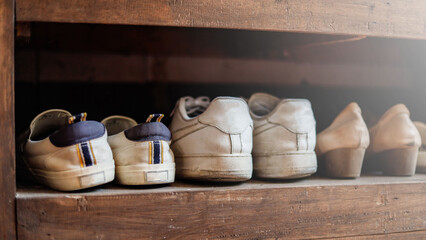 The old shoe rack in the house is a shoe rack with a wooden surface.