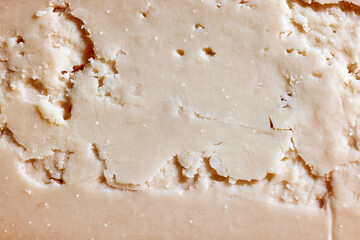 Texture of delicious, organic, natural hard cheese. Sliced. Wallpaper, background. Concept of food, taste, art of organic products, healthy and natural food.
