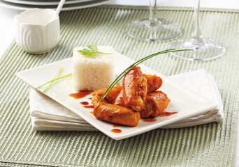Chicken rolls cooked with caramel and served with cooked rice.