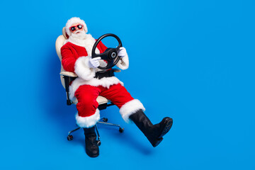 Full size photo of pensioner man sit armchair steering wheel dressed stylish santa claus costume...