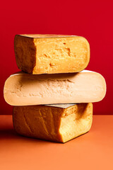 Textures of different cheese, Parmesan, pecorino, cheddar against red background. Cheese production and store. Concept of food, taste, art of organic products, healthy, natural food.
