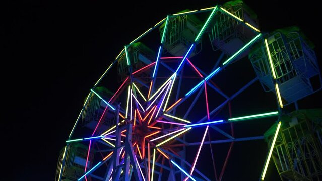 Ferris wheel at night of colorful with outdoor round rotation st Amusement Park with  neon light bottom view