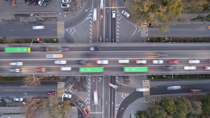 A busy intersection with a lot of cars, buses and trucks. Aerial view from the drone on the night...
