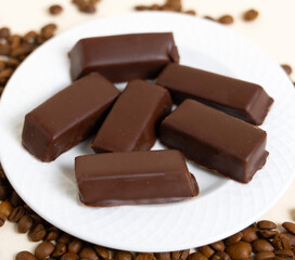 bird's milk,polish soft chocolate covered,candy filled with soft meringue,strawberry or coffee taste,red color.coffee beans and box with sweets,cup with americano.product photography,top view