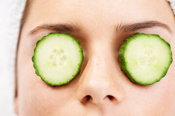 Woman, face and cucumber on eyes for wellness, cosmetic or spa therapy with closeup, relax and...