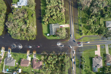 Aerial view of flooded street after hurricane rainfall with driving cars in Florida residential...