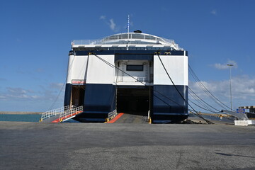 Open stern ramp and aft doors for loading cars and embarking passenger to big ferry with blue and...