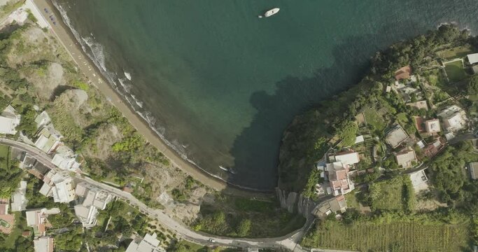 Aerial view of Cala del Vecchio Pozzo beach, a small bay with high cliffs on the Procida island at sunset, Flegree Islands archipelagos, Naples, Campania, Italy.