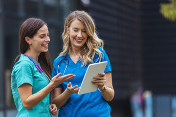Nurses walking and talking. Diversity workers, smile and happy medical healthcare teamwork on treatment collaboration. Shot of two young nurses talking outside