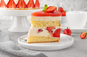 Fraisier mousse cake. Strawberry cake with sponge cake, mousse and jelly on a gray concrete background. Summer dessert. Selective focus. Copy space